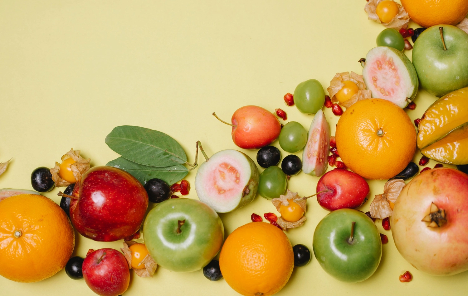 enHealing - Energetischen Praxis, persönlichen Entwicklung und Vitalstoffberatung - Eine Auswahl an frischen Früchten, darunter geschnittene Orangen, Erdbeeren und Blaubeeren, die neben verschiedenen Vitaminkapseln und -pillen auf einer weißen Holzoberfläche verstreut liegen.